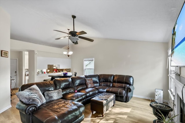 living room with vaulted ceiling, ceiling fan, and light wood-type flooring