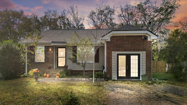 view of front of property with a lawn and french doors