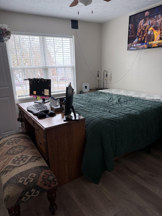 bedroom featuring dark hardwood / wood-style flooring, ceiling fan, multiple windows, and a textured ceiling