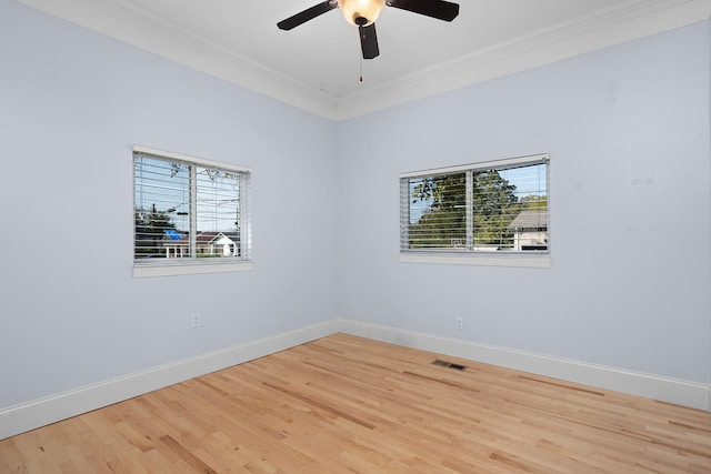 empty room with ceiling fan, ornamental molding, a wealth of natural light, and light wood-type flooring