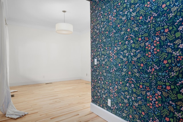 unfurnished room featuring crown molding and hardwood / wood-style flooring