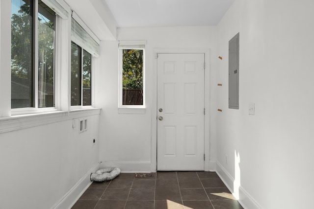 entryway with electric panel and dark tile patterned floors