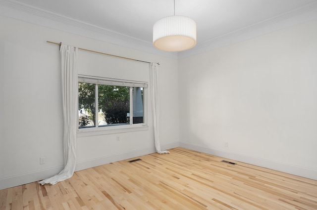 empty room featuring ornamental molding and light hardwood / wood-style flooring