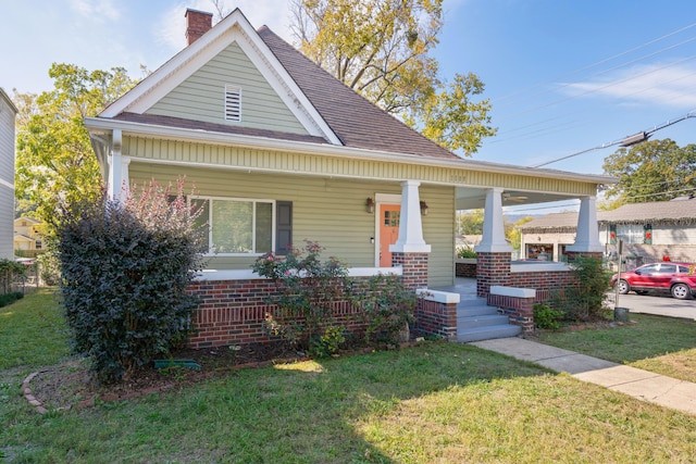 view of front of house featuring covered porch and a front yard