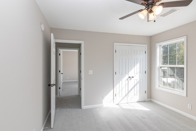 unfurnished bedroom with a closet, ceiling fan, and light carpet