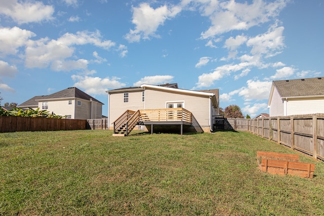 rear view of property with a yard and a deck