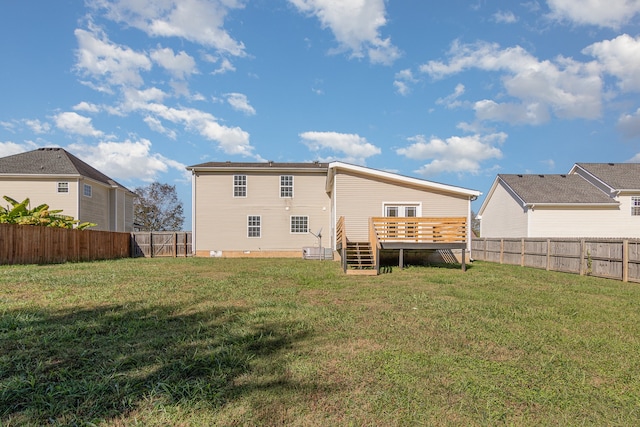 rear view of property with a deck and a lawn