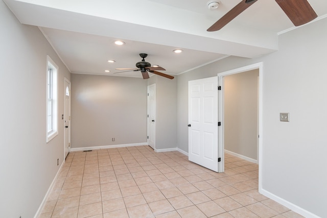 spare room featuring ornamental molding, light tile patterned flooring, and ceiling fan