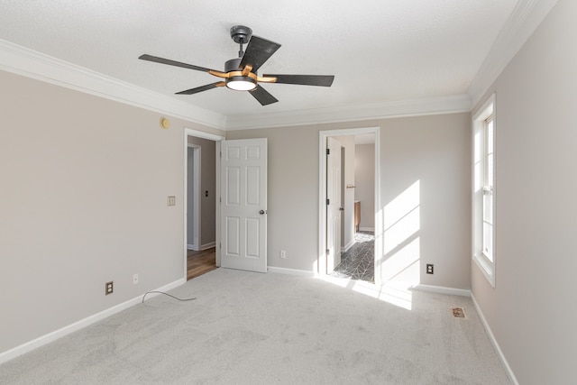 carpeted spare room with ceiling fan and ornamental molding