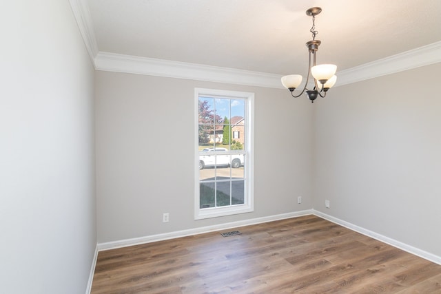 unfurnished room featuring crown molding, hardwood / wood-style flooring, and a chandelier