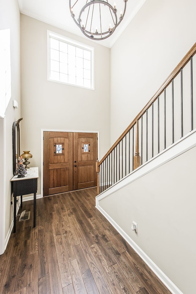 entryway with ornamental molding, dark hardwood / wood-style floors, and a chandelier