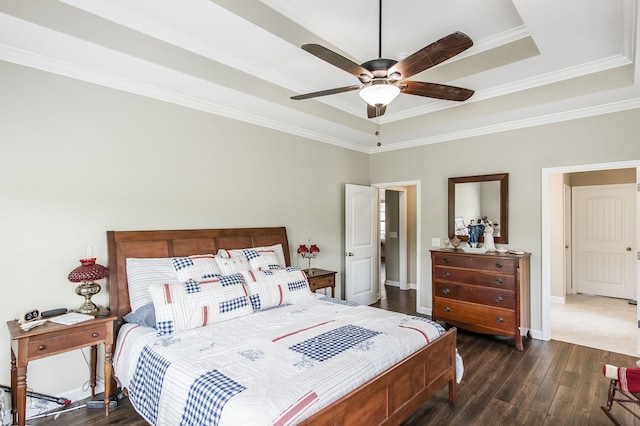 bedroom with ornamental molding, dark wood-type flooring, a raised ceiling, and ceiling fan