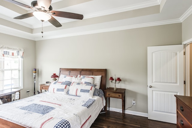 bedroom featuring ornamental molding, dark wood-type flooring, a raised ceiling, and ceiling fan