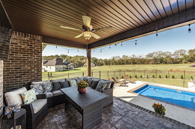 view of patio featuring a rural view, an outdoor living space, a fenced in pool, and ceiling fan