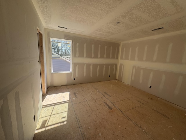 unfurnished room featuring a textured ceiling