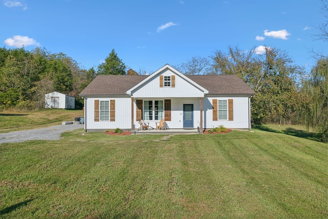 view of front facade featuring covered porch, a storage shed, and a front lawn