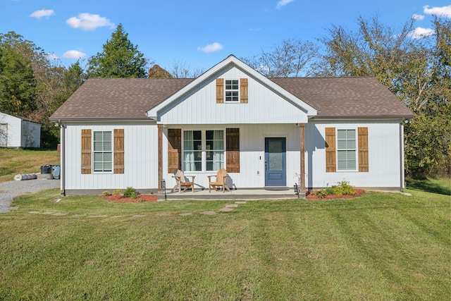 rear view of property featuring a yard and a porch