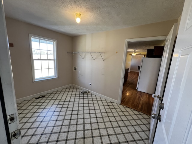 clothes washing area with a textured ceiling, hardwood / wood-style flooring, washer hookup, and ceiling fan