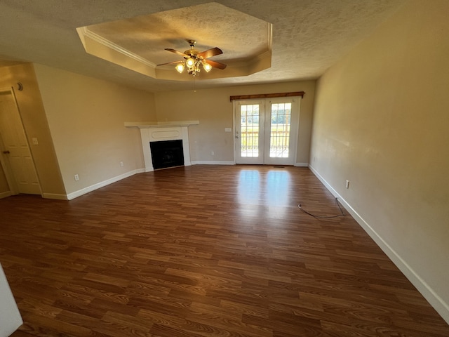 unfurnished living room with a raised ceiling, ceiling fan, a textured ceiling, and dark hardwood / wood-style flooring