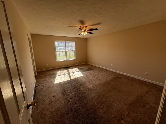 carpeted empty room featuring a textured ceiling and ceiling fan