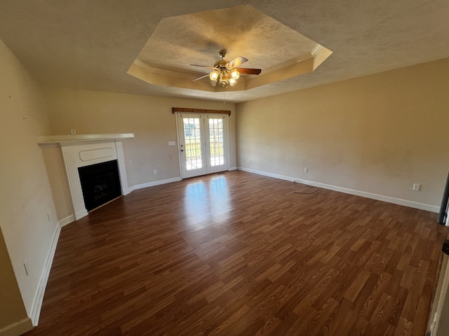 unfurnished living room with french doors, ceiling fan, a raised ceiling, and dark hardwood / wood-style flooring