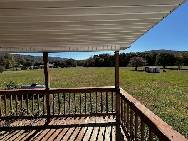 wooden deck with a rural view and a yard