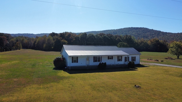 view of front of house with a front yard and a mountain view