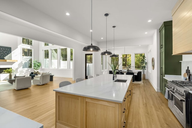 kitchen featuring double oven range, a healthy amount of sunlight, sink, and light brown cabinetry