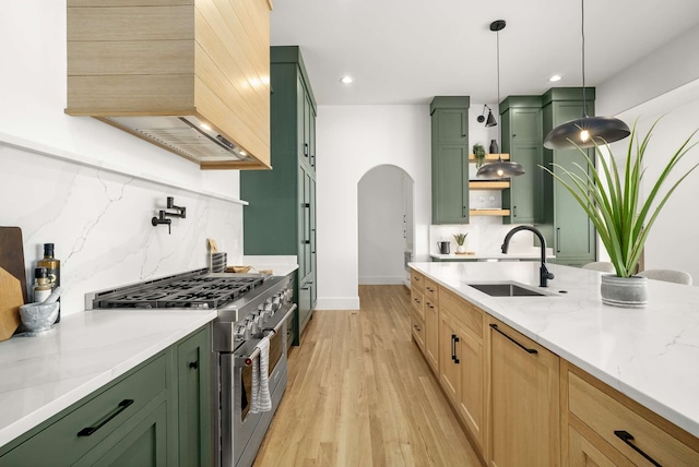 kitchen featuring backsplash, green cabinets, light wood-type flooring, and double oven range