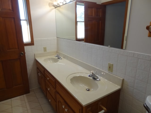 bathroom featuring vanity, tile patterned floors, a wealth of natural light, and tile walls