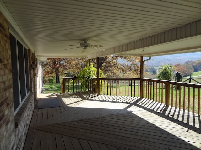 deck with a lawn and ceiling fan