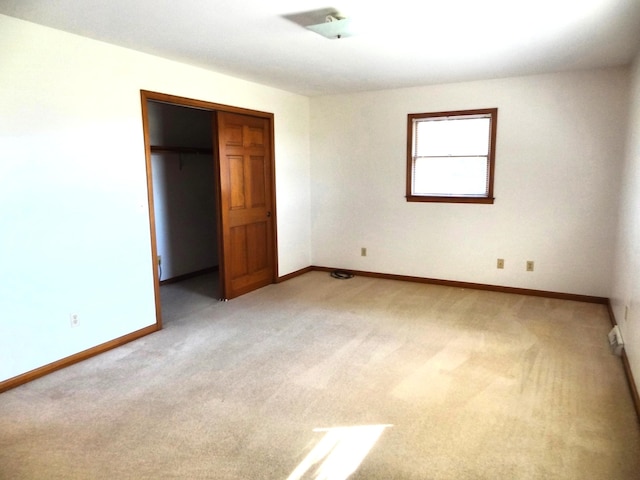 unfurnished bedroom featuring a closet and light colored carpet