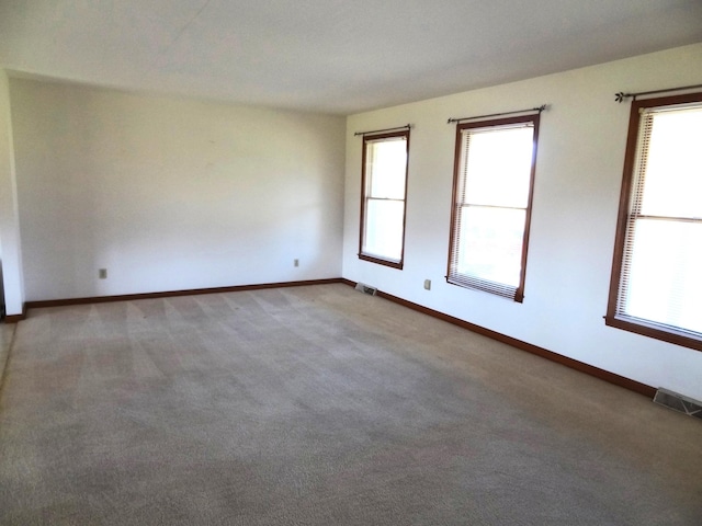 carpeted empty room with a wealth of natural light