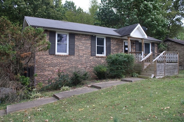 view of front of property featuring a front lawn and a deck