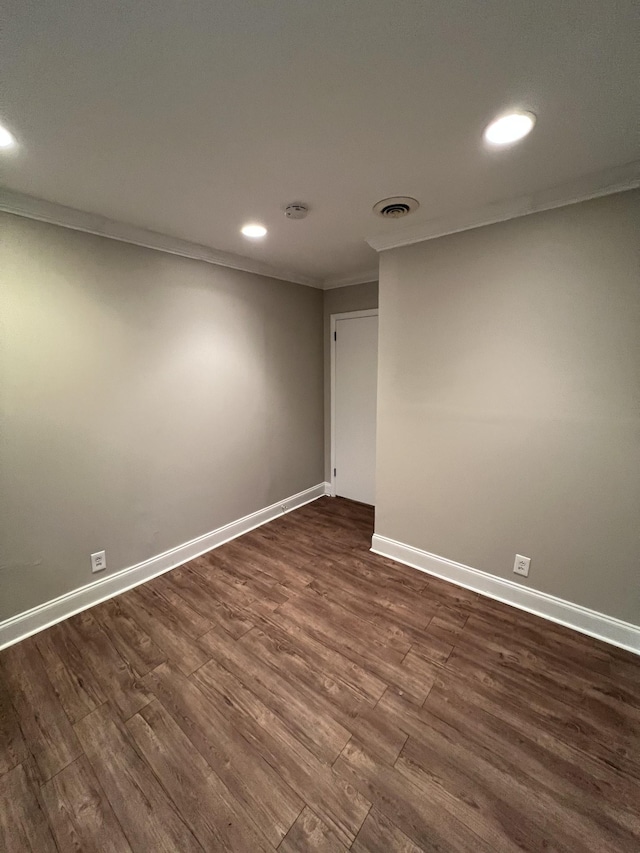 spare room with dark hardwood / wood-style flooring and crown molding