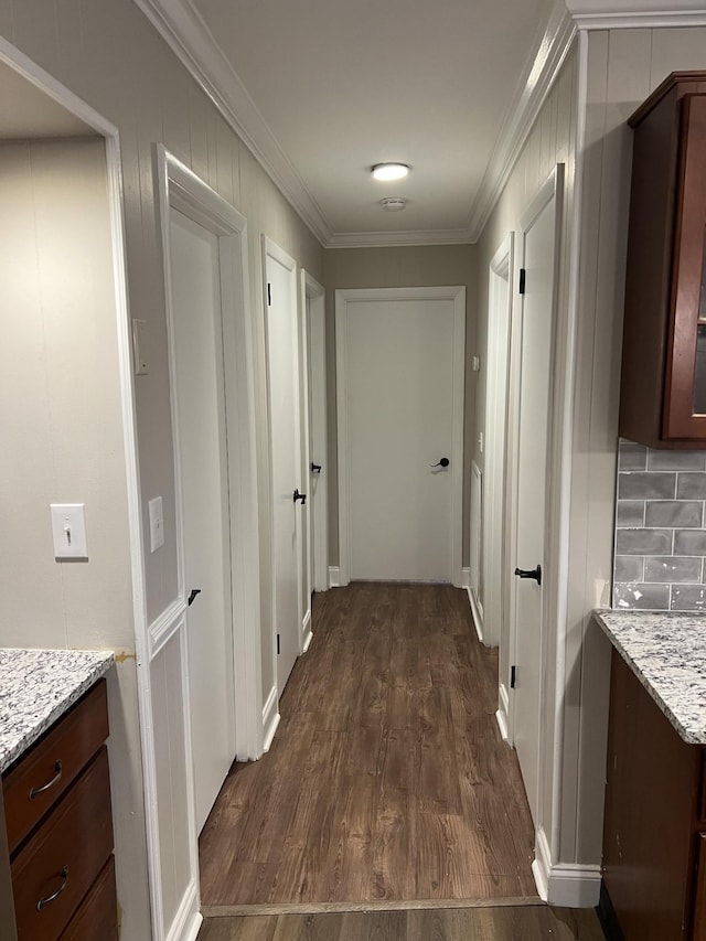 corridor with ornamental molding and dark hardwood / wood-style floors