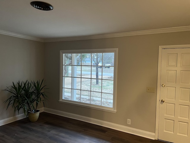 empty room featuring crown molding and dark hardwood / wood-style flooring