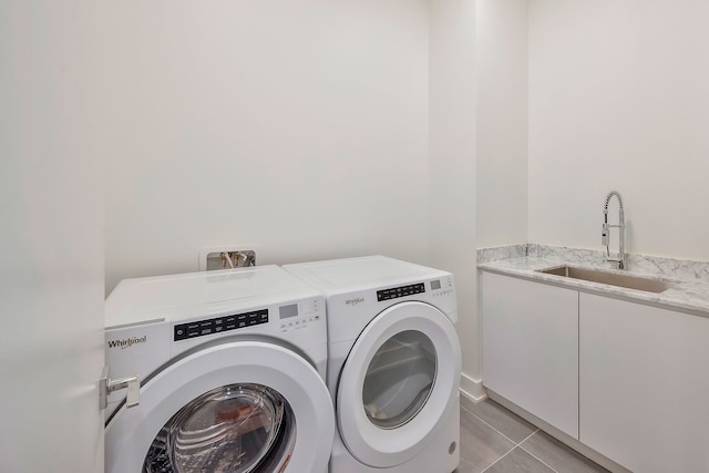 laundry area featuring washer and dryer, light tile patterned flooring, cabinets, and sink