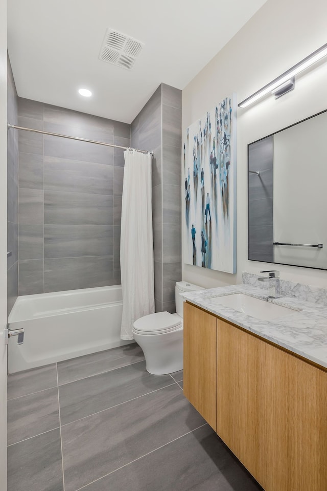 full bathroom featuring toilet, tile patterned floors, vanity, and shower / tub combo with curtain