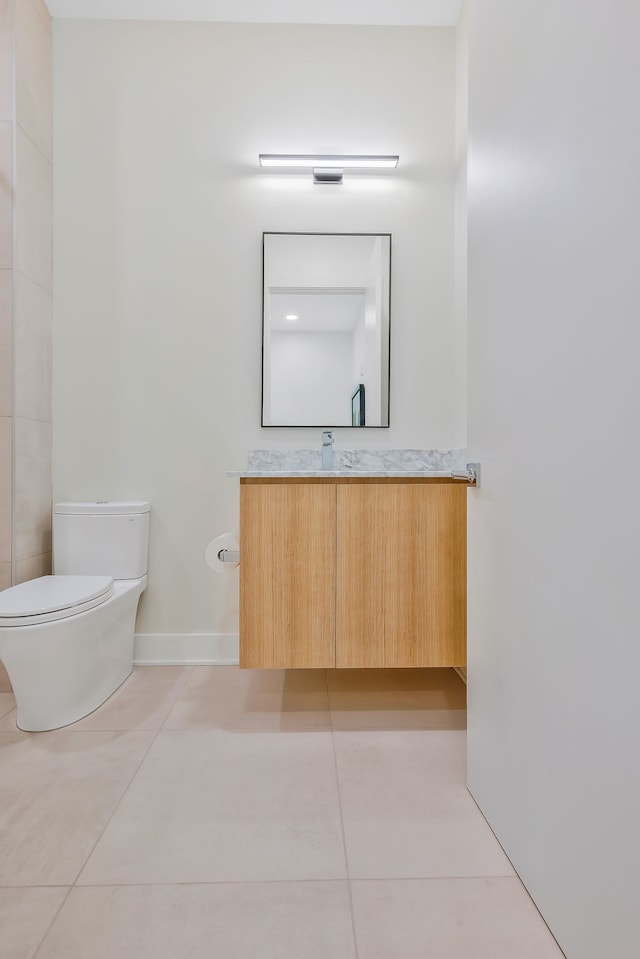 bathroom with tile patterned flooring, vanity, and toilet