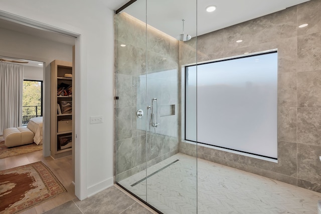 bathroom featuring tile patterned flooring and a tile shower