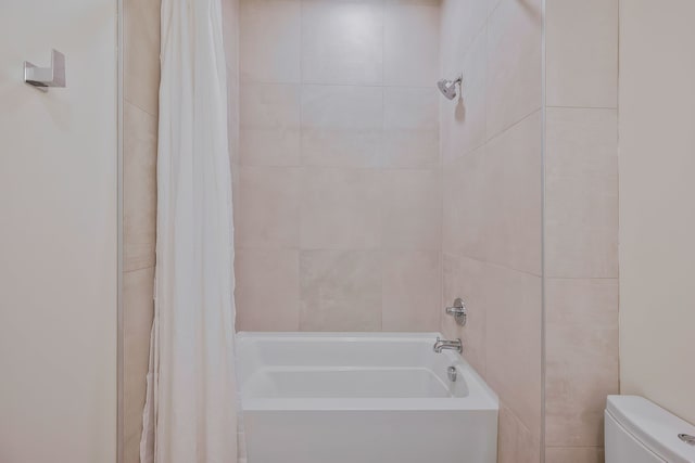 bathroom featuring shower / bath combo and toilet