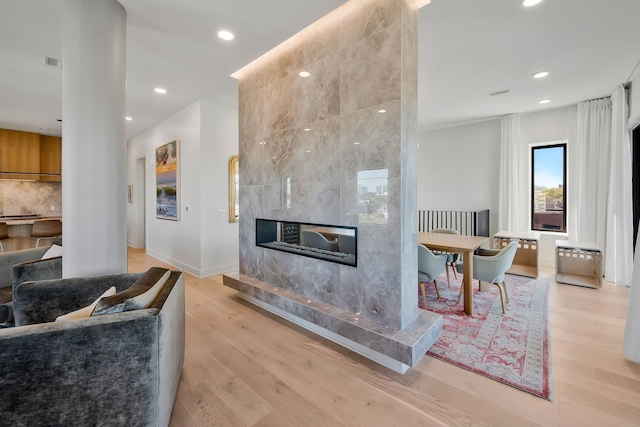 living room with a fireplace and light hardwood / wood-style flooring