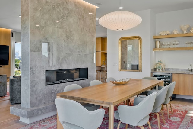 dining space with light hardwood / wood-style flooring and a tiled fireplace