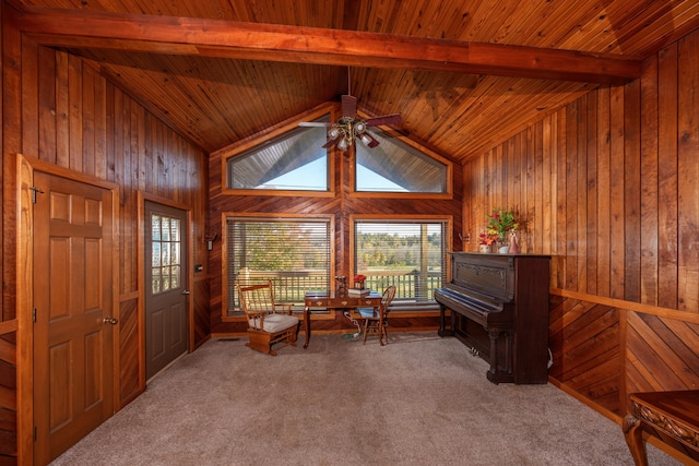 unfurnished room featuring beam ceiling, wood walls, carpet, and wood ceiling