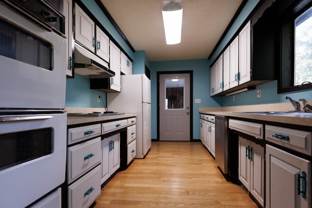 kitchen with sink, light hardwood / wood-style floors, double oven, and white cabinets