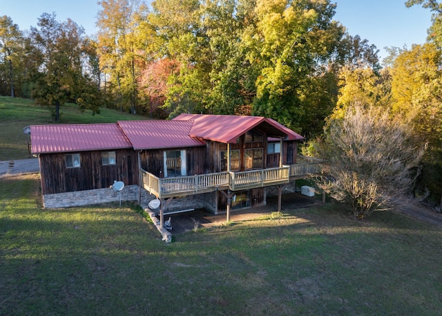 rear view of house with a deck and a lawn