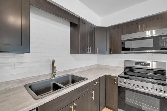 kitchen featuring dark brown cabinets, sink, stainless steel appliances, and tasteful backsplash