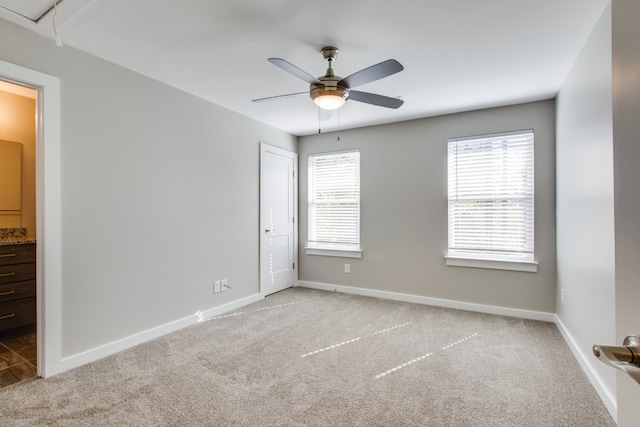 carpeted spare room with ceiling fan and a wealth of natural light