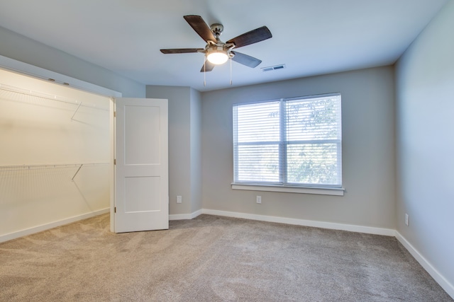 unfurnished bedroom featuring light colored carpet, a closet, and ceiling fan